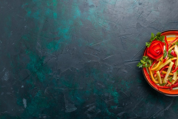 Vista dall'alto peperoni affettati insalata di colore diverso all'interno della piastra sullo sfondo scuro