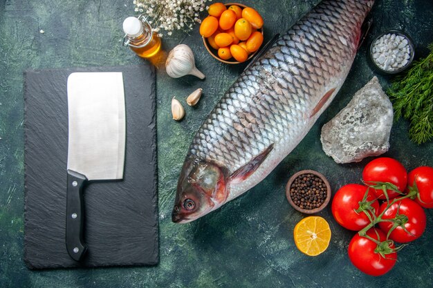 vista dall'alto pesce crudo fresco con pomodori rossi su sfondo scuro