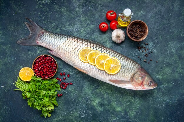 Vista dall'alto pesce crudo pomodori fette di limone olio verde bottiglia sul tavolo spazio libero