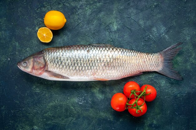 Vista dall'alto pesce crudo pomodori limone sul tavolo con posto copia