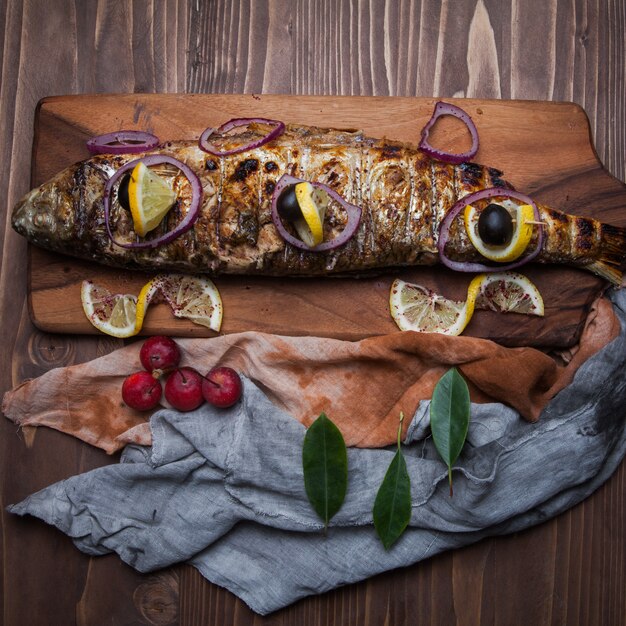 Vista dall'alto pesce fritto con limone e paradiso mele e cipolla nel tagliere