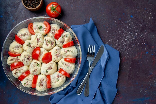 Vista dall'alto pezzi di pasta cruda con carne macinata e pomodori sul piatto da cucina scuro cucina foto colore cibo insalata