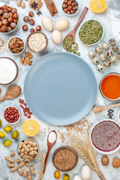 Vista dall'alto piatto blu con uova di gelatina di farina e noci diverse su frutta bianca noci zucchero foto torta pasta colorata torta