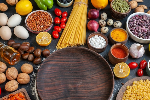 Vista dall'alto piatto marrone attorno a diversi ingredienti su sfondo scuro pasto cibo colore dado pasta piatto di pasta frutti