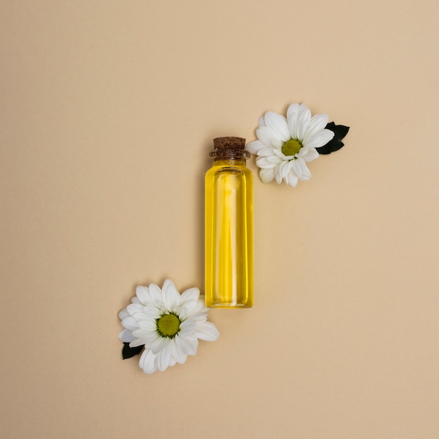 Vista dall'alto piccola bottiglia di olio con fiori