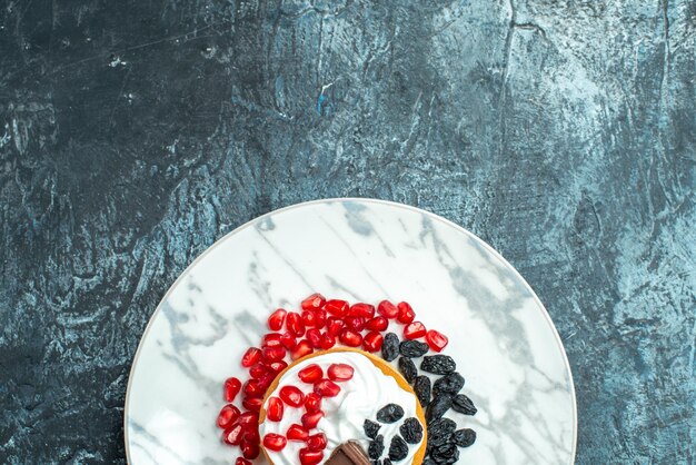 Vista dall'alto piccola deliziosa torta con cioccolato e uvetta su sfondo chiaro-scuro