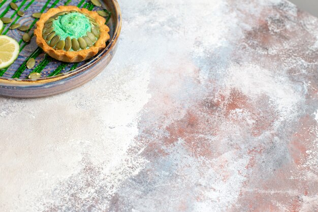 Vista dall'alto piccola torta cremosa con frutta all'interno del vassoio