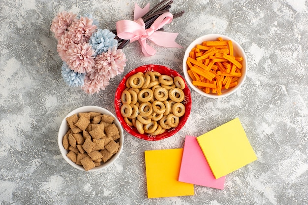 Vista dall'alto piccoli cracker con biscotti e fette biscottate sulla superficie bianca