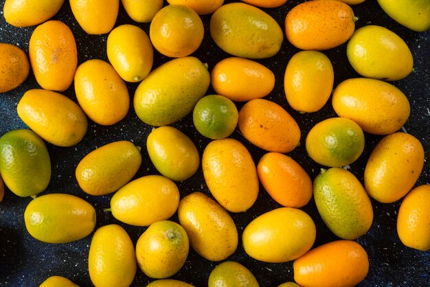 Vista dall'alto. Pila di kumquat sulla superficie blu