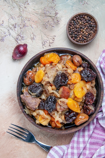 Vista dall'alto pilaf un appetitoso pilaf forcella cipolla pepe nero la tovaglia