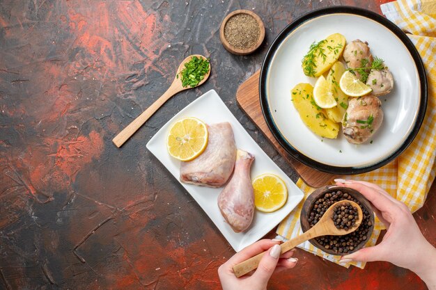 Vista dall'alto pollo bollito con condimenti di patate cotte e limone su sfondo scuro colore pasto salsa carne piatto cucina cibo cena