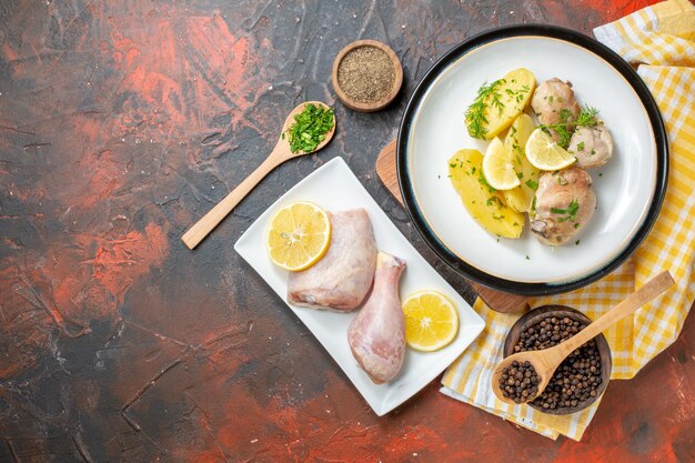 Vista dall'alto pollo bollito con condimenti di patate cotte e limone su sfondo scuro salsa cucina piatto colore cena carne cibo