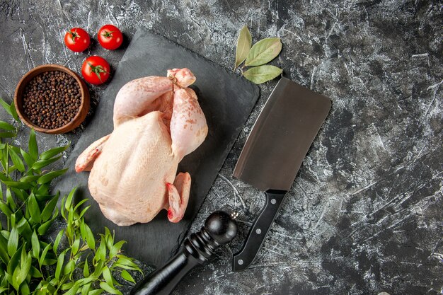 Vista dall'alto pollo crudo fresco con pomodori su sfondo chiaro-scuro pasto da cucina foto animale carne di pollo colore cibo