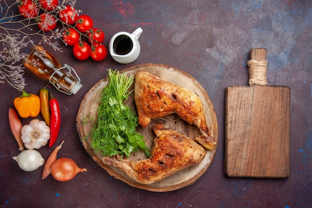 Vista dall'alto pollo fritto con verdure e verdure sulla scrivania scura