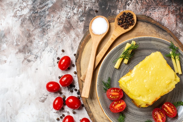 Vista dall'alto pomodori di pane all'aglio di formaggio sul piatto cucchiai di legno su tavola da portata rustica pomodorini sul tavolo