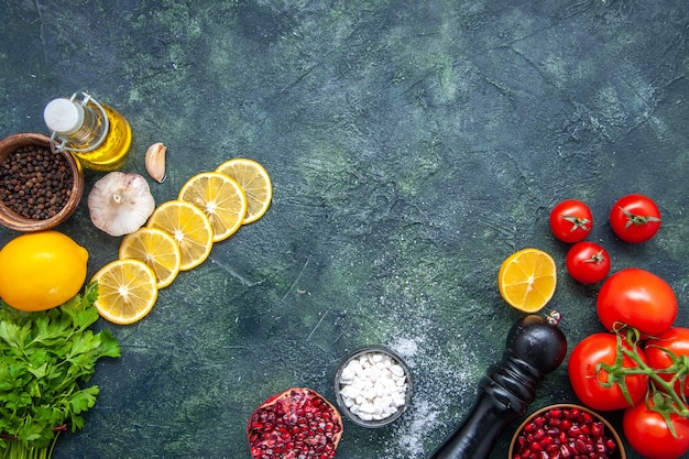 Vista dall'alto pomodori freschi bottiglia di olio macinapepe fette di limone sul tavolo della cucina con posto copia