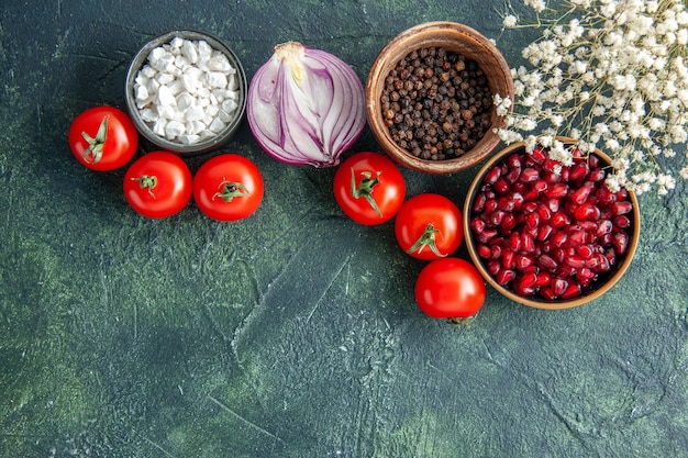 Vista dall'alto pomodori rossi freschi con condimenti su uno sfondo scuro salute pasto insalata di cibo foto a colori dieta