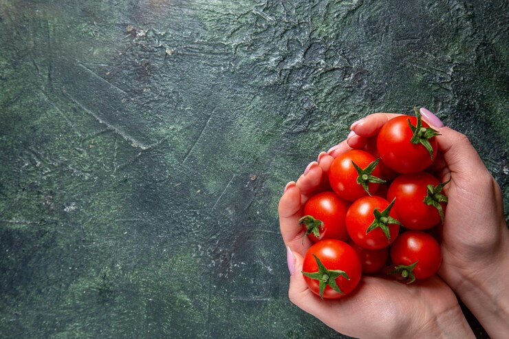 Foto gratuito vista dall'alto pomodori rossi freschi in mani femminili sulla superficie scura