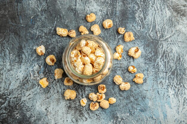 Vista dall'alto popcorn dolce all'interno della latta di vetro sulla superficie chiara