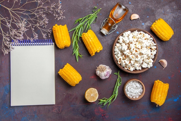 Vista dall'alto popcorn fresco con calli gialli crudi sulla pianta del film di mais popcorn snack superficie scura