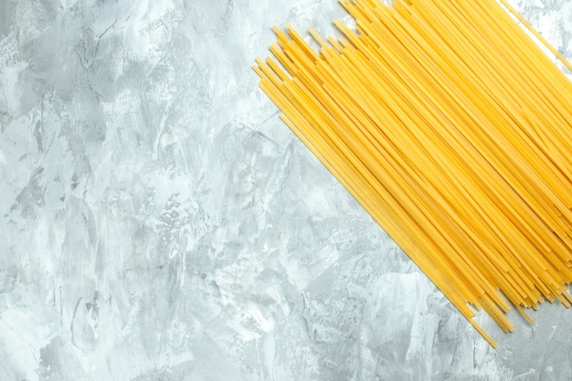 Vista dall'alto prodotto crudo di pasta lunga italiana su sfondo bianco