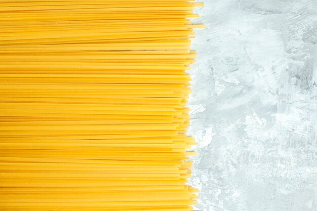 Vista dall'alto prodotto crudo di pasta lunga italiana su sfondo bianco