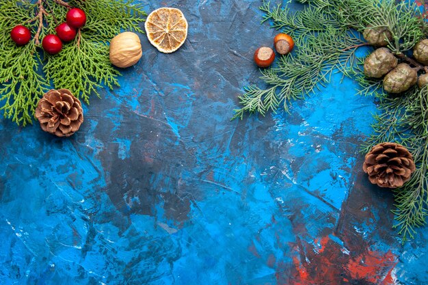 Vista dall'alto rami di abete rami di abete coni albero di natale giocattoli su sfondo blu