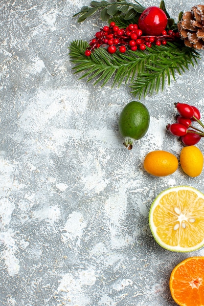 Vista dall'alto rami di alberi di Natale tagliati limoni feijoas sul tavolo grigio con spazio libero