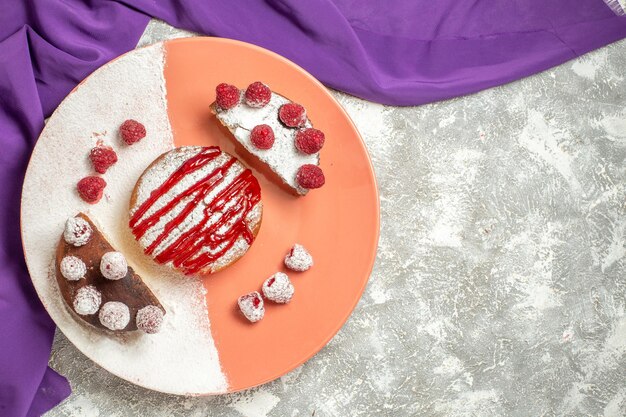Vista dall'alto ravvicinata del piatto di dessert su un tovagliolo viola con posto libero per il testo su sfondo di marmo
