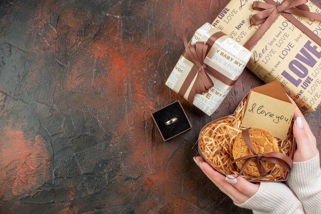 Vista dall'alto regali di san valentino con anello su sfondo marrone scuro amore coppia colore regalo matrimonio vacanza