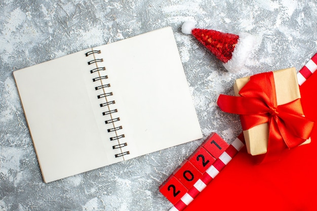 Vista dall'alto regalo di Natale con blocchi di legno cappello da Babbo Natale sul tavolo grigio bianco