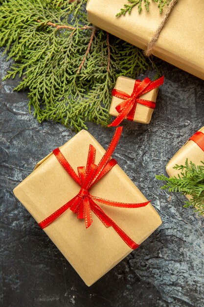 Vista dall'alto regalo di natale piccoli regali rami di pino su superficie grigia