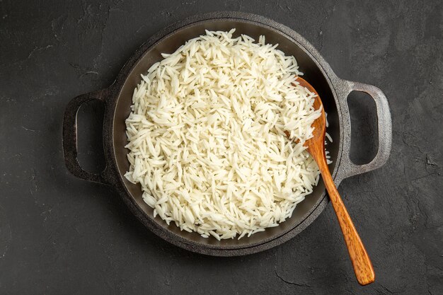 Vista dall'alto riso cotto all'interno della padella sulla superficie scura pasto cena cibo riso orientale