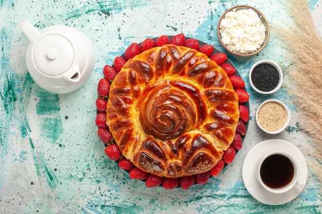 Vista dall'alto rotonda deliziosa torta con fragole fresche sulla scrivania blu