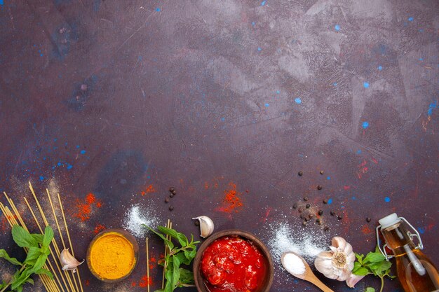 Vista dall'alto salsa di pomodoro con condimenti su sfondo scuro pasto salsa piccante