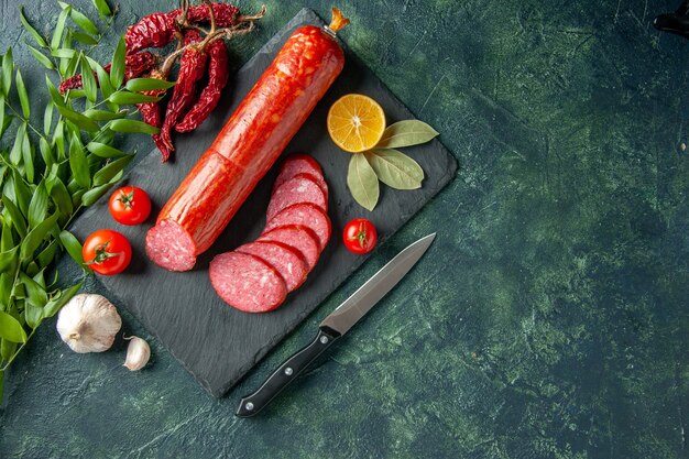 Vista dall'alto salsiccia fresca e gustosa con pomodori su sfondo blu pane carne cibo hamburger panino panino colore