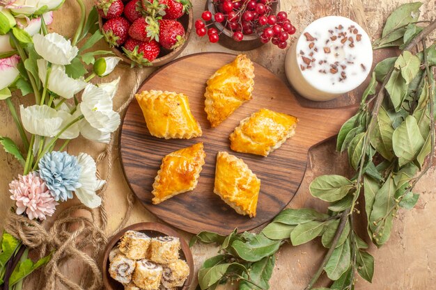 Vista dall'alto squisiti pasticcini dado con frutta sulla scrivania in legno