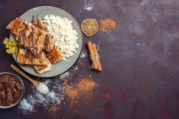 Vista dall'alto squisiti pasticcini dolci affettati con ricotta su sfondo viola scuro tè biscotto biscotto zucchero torta dolce