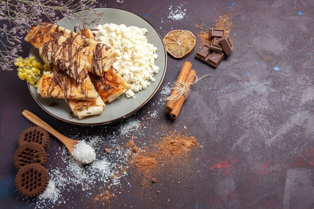 Vista dall'alto squisiti pasticcini dolci con ricotta e biscotti su sfondo scuro biscotto zucchero torta dolce tè