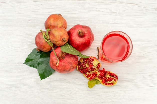 Vista dall'alto succo di melograno fresco con melograni freschi sul colore della frutta bevanda succo di superficie bianca