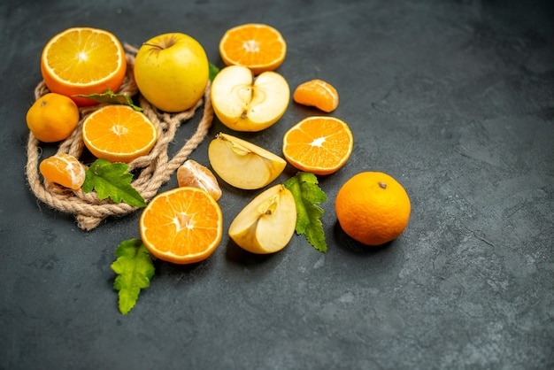 Vista dall'alto tagliare le arance e le mele tagliate l'arancia su una superficie scura