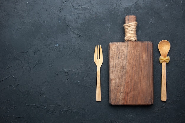 Vista dall'alto tavola di servizio in legno cucchiaio e forchetta di legno sul posto di copia tavolo scuro
