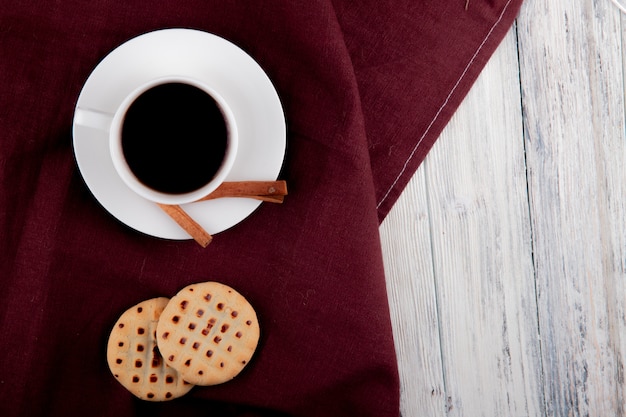 vista dall'alto Tazza di caffè a sinistra con biscotti alla cannella con ripieno e copia spazio su fondo di legno bianco