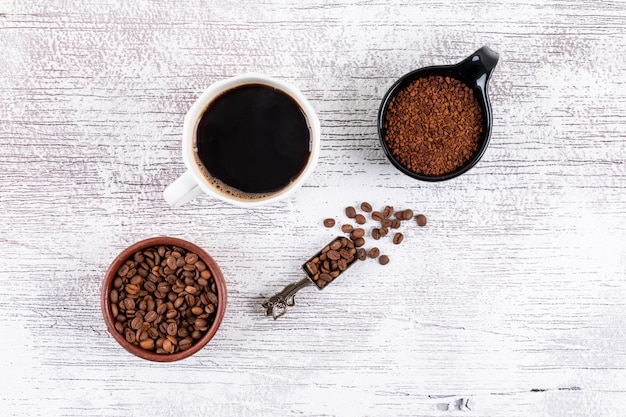 vista dall'alto tazza di caffè con chicchi di caffè e caffè istantaneo sul tavolo bianco