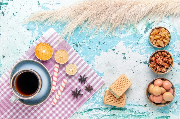 Vista dall'alto tazza di caffè con cialde di uvetta e confetture sullo sfondo azzurro torta cuocere dolce torta di zucchero