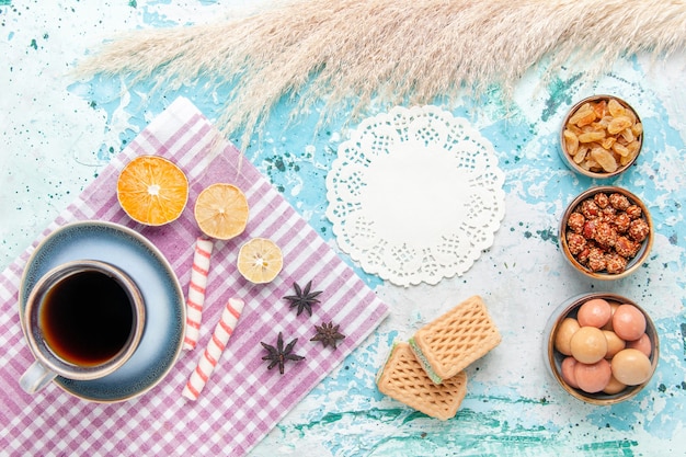 Vista dall'alto tazza di caffè con cialde di uvetta e confetture sullo sfondo azzurro torta cuocere dolce torta di zucchero