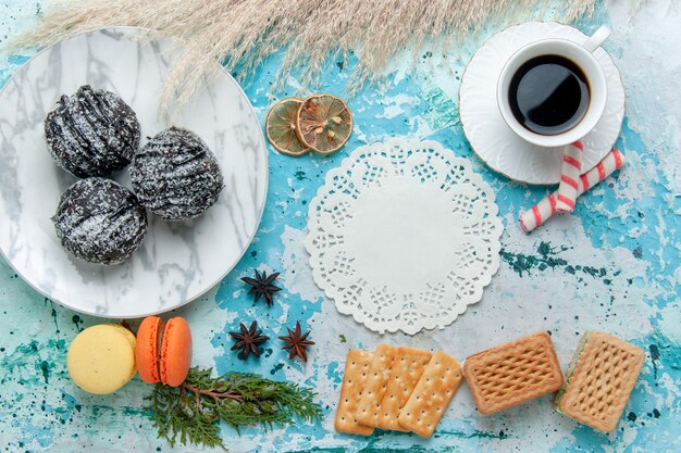 Vista dall'alto tazza di caffè con cialde e torte al cioccolato sullo sfondo blu torta cuocere biscotti al cioccolato dolce zucchero colore