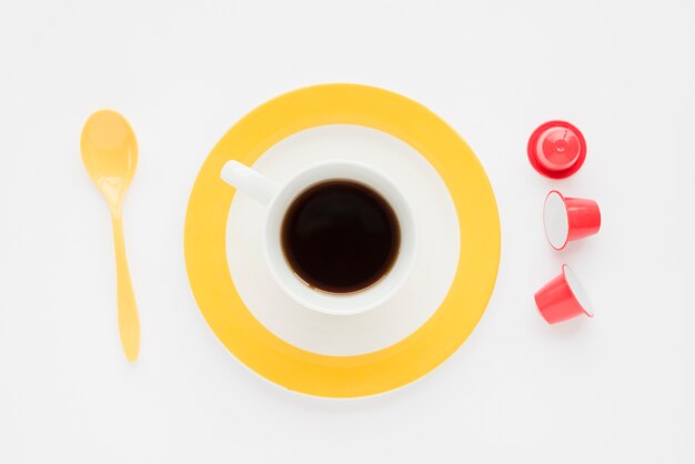 Vista dall&#39;alto tazza di caffè con cucchiaio e capsule