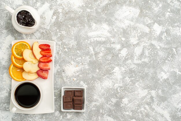 Vista dall'alto tazza di caffè con marmellata di mele a fette arance e fragole su uno sfondo bianco chiaro frutta matura fresca pastosa