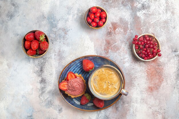 Vista dall'alto tazza di caffè con torta cremosa e frutta sulla torta biscotto dolce tavolo luminoso